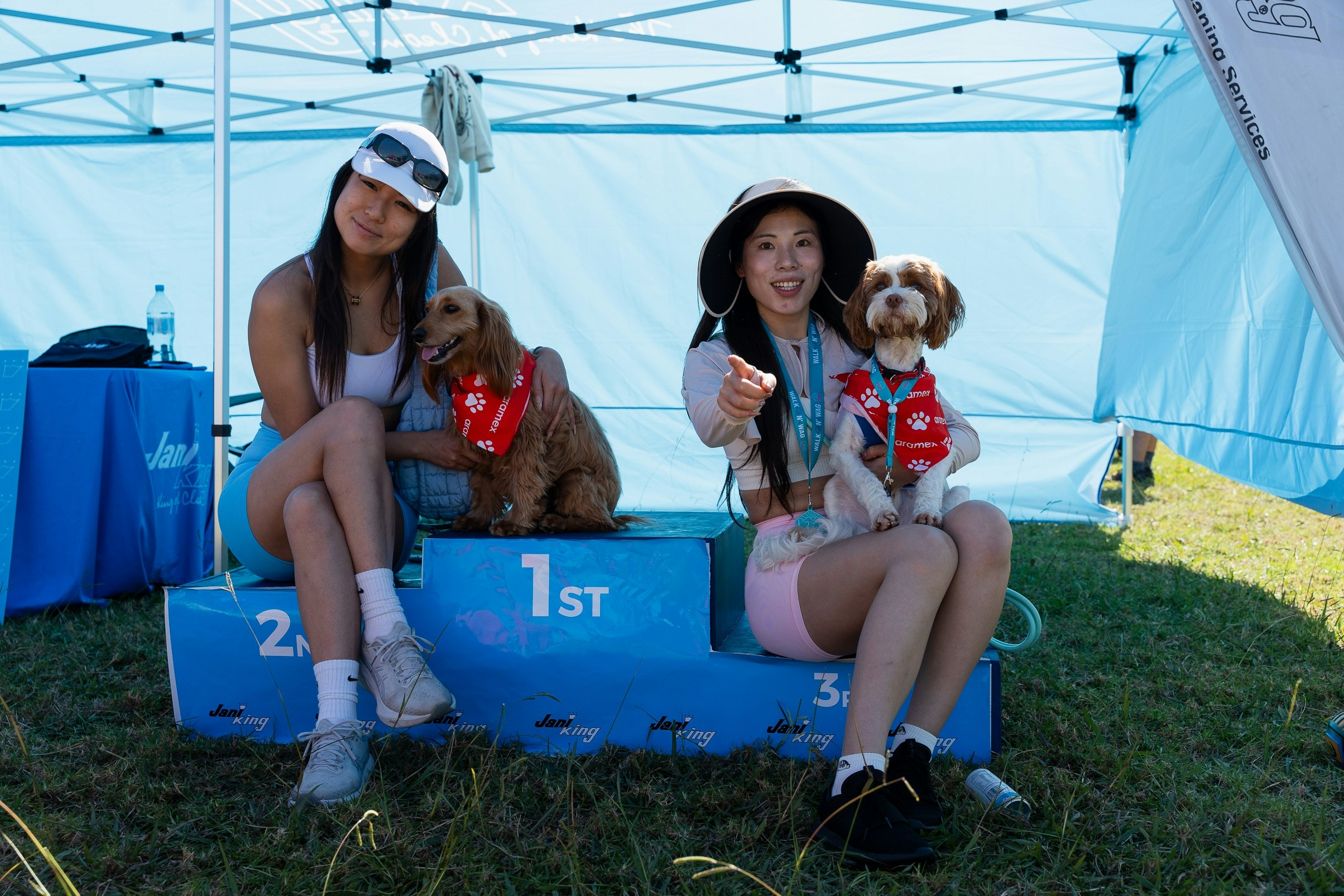Happy people holding dogs on jani king podium